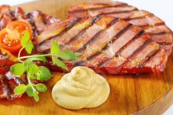 Slices of smoked pork neck and mustard