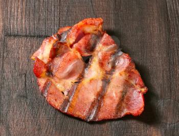 Grilled thin sliced pork on dark brown wood