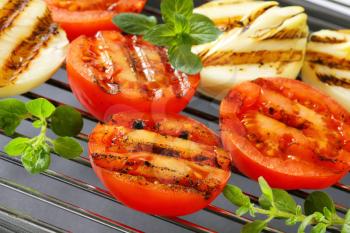 Grilled tomatoes and onions on barbecue grid