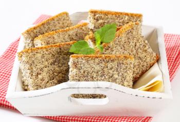 Slices of poppy seed cake on wooden serving tray