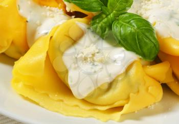 Spinach and ricotta stuffed pasta served with white cream sauce and grated Parmigiano