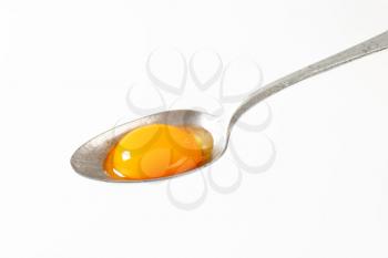 Raw egg yolk on a spoon