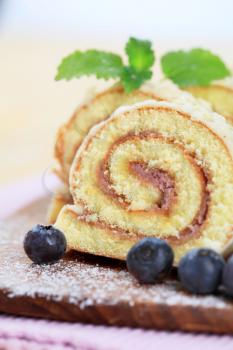 Slices of Swiss roll and fresh blueberries