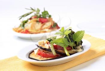 Slices of grilled aubergine and tomato with cheese