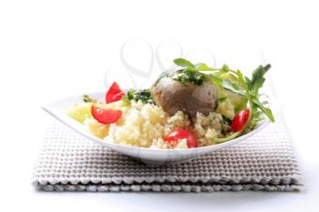 Couscous with tomatoes garnished with mushroom and greens