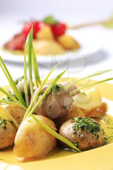 New potatoes and button mushrooms garnished with spring onion