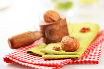 Wooden nutcracker and walnuts on tea towels