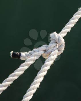 Tight knot on a white rope - closeup