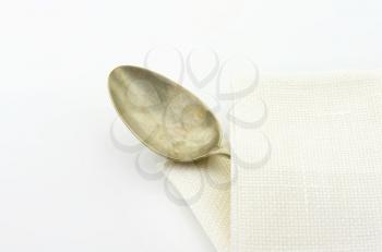 Old silver spoon in white serviette