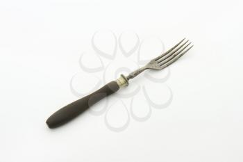 Old rusty dinner fork with wood handle