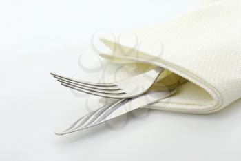 Dinner knife and fork in white napkin