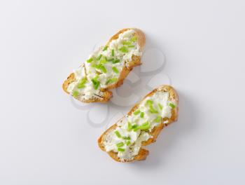 Crunchy baguette slices with cheese spread and chives