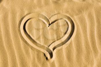 Heart drawn in the sand on the beach
