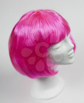 Pink wig on a white mannequin head 