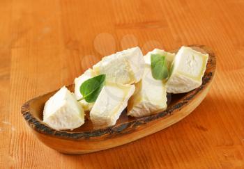 Pieces of goat cheese in natural edge bowl