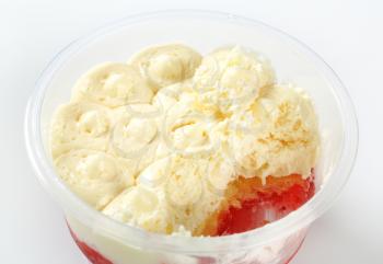 Half-eaten strawberry shortcake dessert in plastic cup