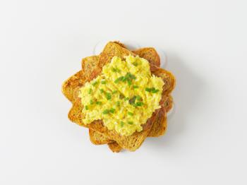 Scrambled eggs with chopped chives on toast