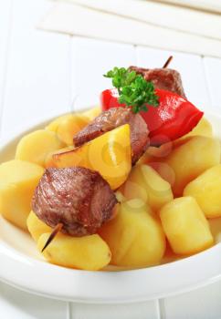 Grilled meat on skewer served with potatoes