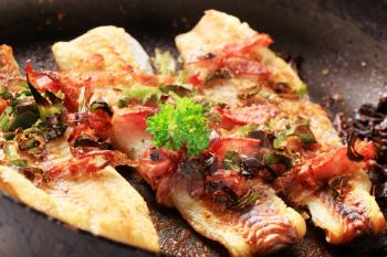 Pan fried fish fillets with bacon and spring onion