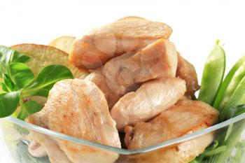 Cooked chicken breast fillets with snow peas and apple