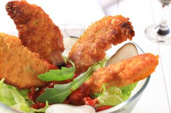Crispy chicken tenders with tomato dipping sauce and lettuce