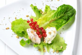 Cheese spread on lettuce leaves sprinkled with pine nuts