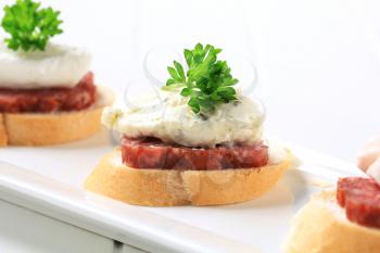 Canapes with spicy salami and savory spread