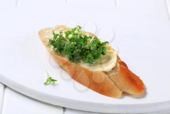 Slice of baguette with butter and cress