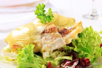 Cheese topped fish fillets served with salad
