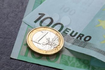 One euro coin and bank note