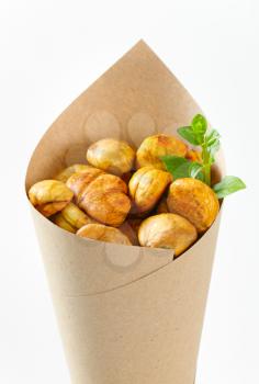 Peeled roasted chestnuts in a paper cone
