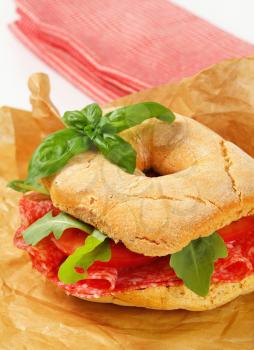 Italian bread roll with thin slices of dry salami
