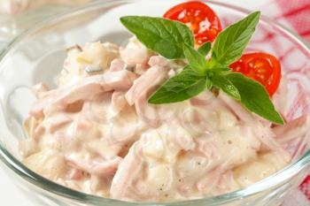 Ham and potato salad in a glass serving bowl