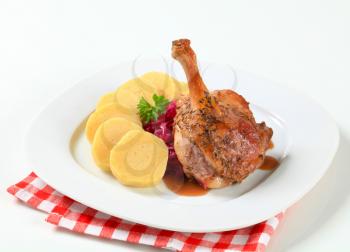 Dish of roast duck leg with potato dumplings and red cabbage