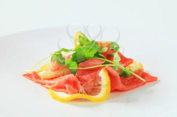 Lemon and beef carpaccio sprinkled with arugula