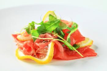 Lemon and beef carpaccio sprinkled with arugula