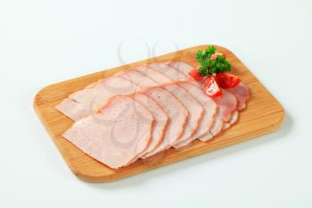 Thinly sliced turkey breast on cutting board
