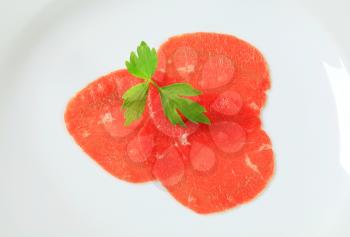 Thinly sliced raw beef meat on plate