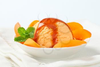 Ice cream with caramel sauce and apricot wedges