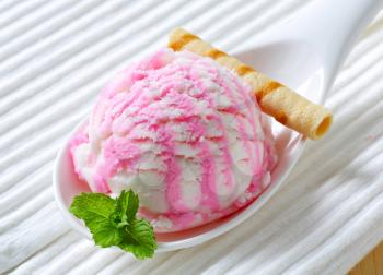 Scoop of raspberry yogurt ice cream on porcelain spoon