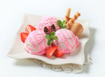 Ice cream sundae with strawberries and wafer rolls