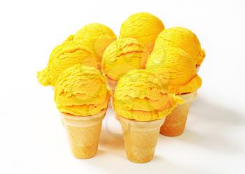 Scoops of yellow ice cream in wafer cones