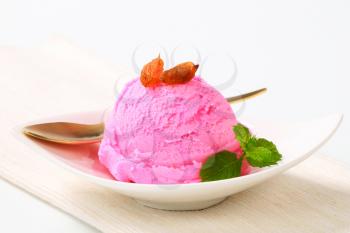 Scoop of pink ice cream on a dessert plate