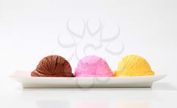 Scoops of ice cream on a long plate - three flavors