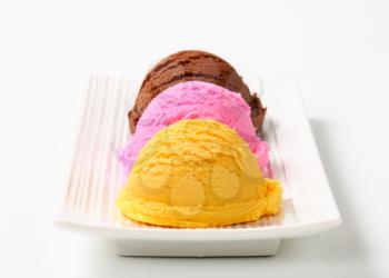Three scoops of ice cream on a long plate
