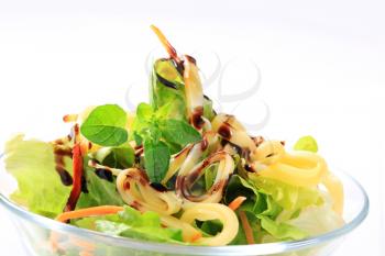 Crisp lettuce with strips of cheese and drizzle of balsamic vinegar