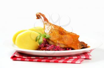Dish of roast duck leg with potato dumplings and braised red cabbage