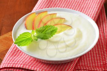 Bowl of smooth milk pudding with apple slices