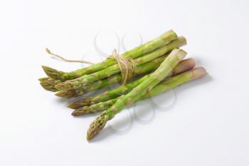 Bundle of fresh asparagus on white background