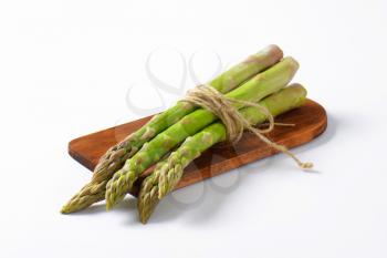 Bundle of fresh asparagus on cutting board